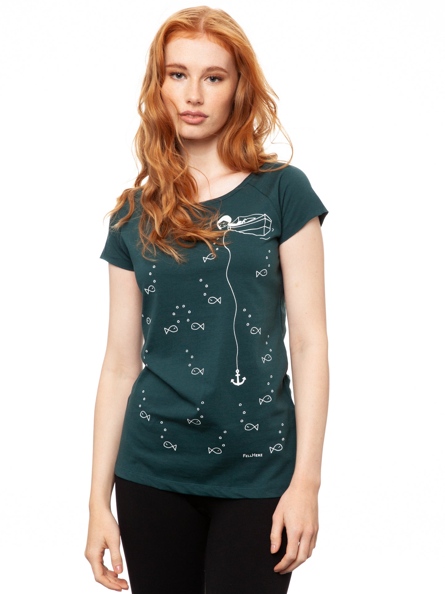 Ein Model trägt ein petrolfarbens Damen T‑Shirt aus 100 % Bio‑Baumwolle mit kurzen Cap‑Sleeves, maritimem Anker‑Siebdruck vorne und kleinem Logo‑Print auf dem Rücken – nachhaltig, fair produziert und lässig geschnitten