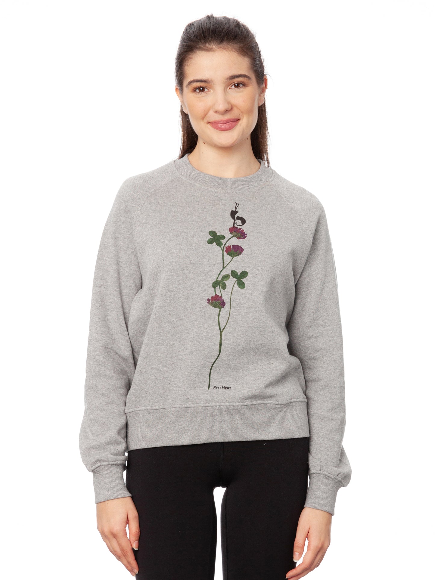 Damen Sweater hellgrau meliert mit Glücksklee-Design aus Biobaumwolle, Fair & Vegan hergestellt. Stilvoller Frauen Pullover mit nachhaltigem Druck ohne Schadstoffe – Fair Fashion von FellHerz. Der Grafik Print auf der Vorderseite zeigt ein kleines Mädchen, das Handstand macht auf einer blühenden Klee-Pflanze.