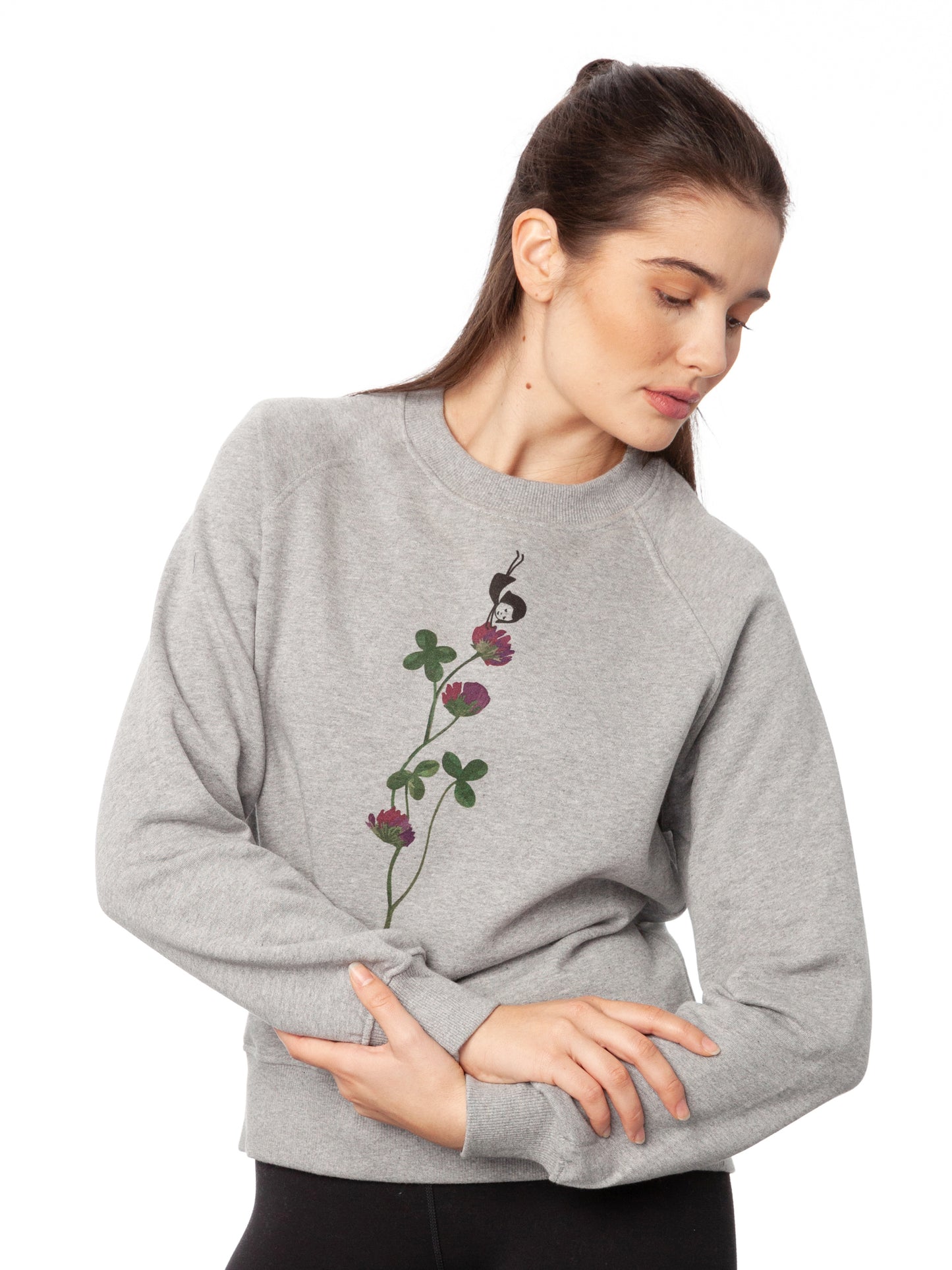 Damen Sweater hellgrau meliert mit Glücksklee-Design aus Biobaumwolle, Fair & Vegan hergestellt. Stilvoller Frauen Pullover mit nachhaltigem Druck ohne Schadstoffe – Fair Fashion von FellHerz. Der Grafik Print auf der Vorderseite zeigt ein kleines Mädchen, das Handstand macht auf einer blühenden Klee-Pflanze.