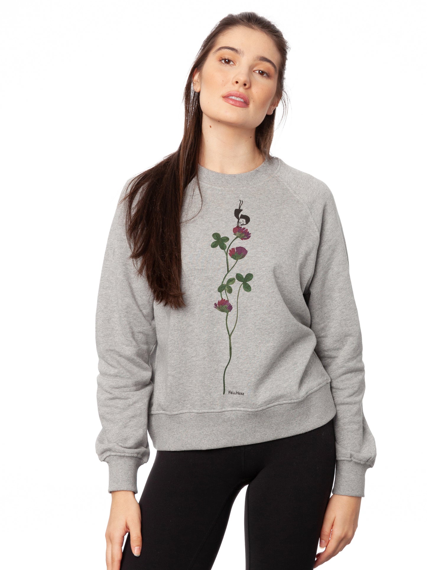 Damen Sweater hellgrau meliert mit Glücksklee-Design aus Biobaumwolle, Fair & Vegan hergestellt. Stilvoller Frauen Pullover mit nachhaltigem Druck ohne Schadstoffe – Fair Fashion von FellHerz. Der Grafik Print auf der Vorderseite zeigt ein kleines Mädchen, das Handstand macht auf einer blühenden Klee-Pflanze.
