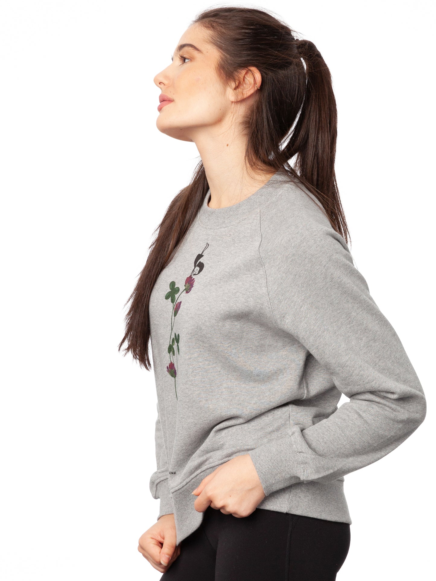Damen Sweater hellgrau meliert mit Glücksklee-Design aus Biobaumwolle, Fair & Vegan hergestellt. Stilvoller Frauen Pullover mit nachhaltigem Druck ohne Schadstoffe – Fair Fashion von FellHerz. Der Grafik Print auf der Vorderseite zeigt ein kleines Mädchen, das Handstand macht auf einer blühenden Klee-Pflanze.