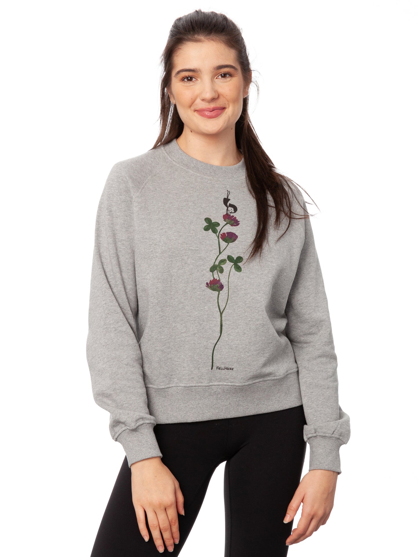 Damen Sweater hellgrau meliert mit Glücksklee-Design aus Biobaumwolle, Fair & Vegan hergestellt. Stilvoller Frauen Pullover mit nachhaltigem Druck ohne Schadstoffe – Fair Fashion von FellHerz. Der Grafik Print auf der Vorderseite zeigt ein kleines Mädchen, das Handstand macht auf einer blühenden Klee-Pflanze.