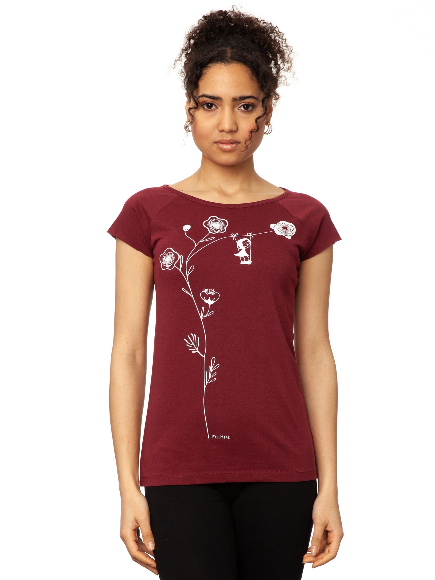Ein Damen-T-Shirt in kräftigem Rubinrot mit kurzen Cap-Ärmeln. Auf der Vorderseite ist ein filigranes Siebdruck-Motiv eines Mädchens auf einer Schaukel zu sehen, die an einem Kirschblüten Zweig hängt. Das T-Shirt hat eine leicht taillierte Passform und besteht aus weicher Bio-Baumwolle und ist nachhaltig und fair produziert.