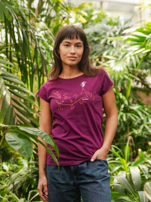 Lila Frauen Yoga T-Shirt mit Asana-Girl-Print auf der Brust: ein brauner Ast mit pinken Beeren, auf denen ein kleines Mädchen in Balance-Yogapose steht -nachhaltig produziert aus Bio-Baumwolle – modernes Cap Sleeve Shirt für Yoga, Freizeit und Meditation.