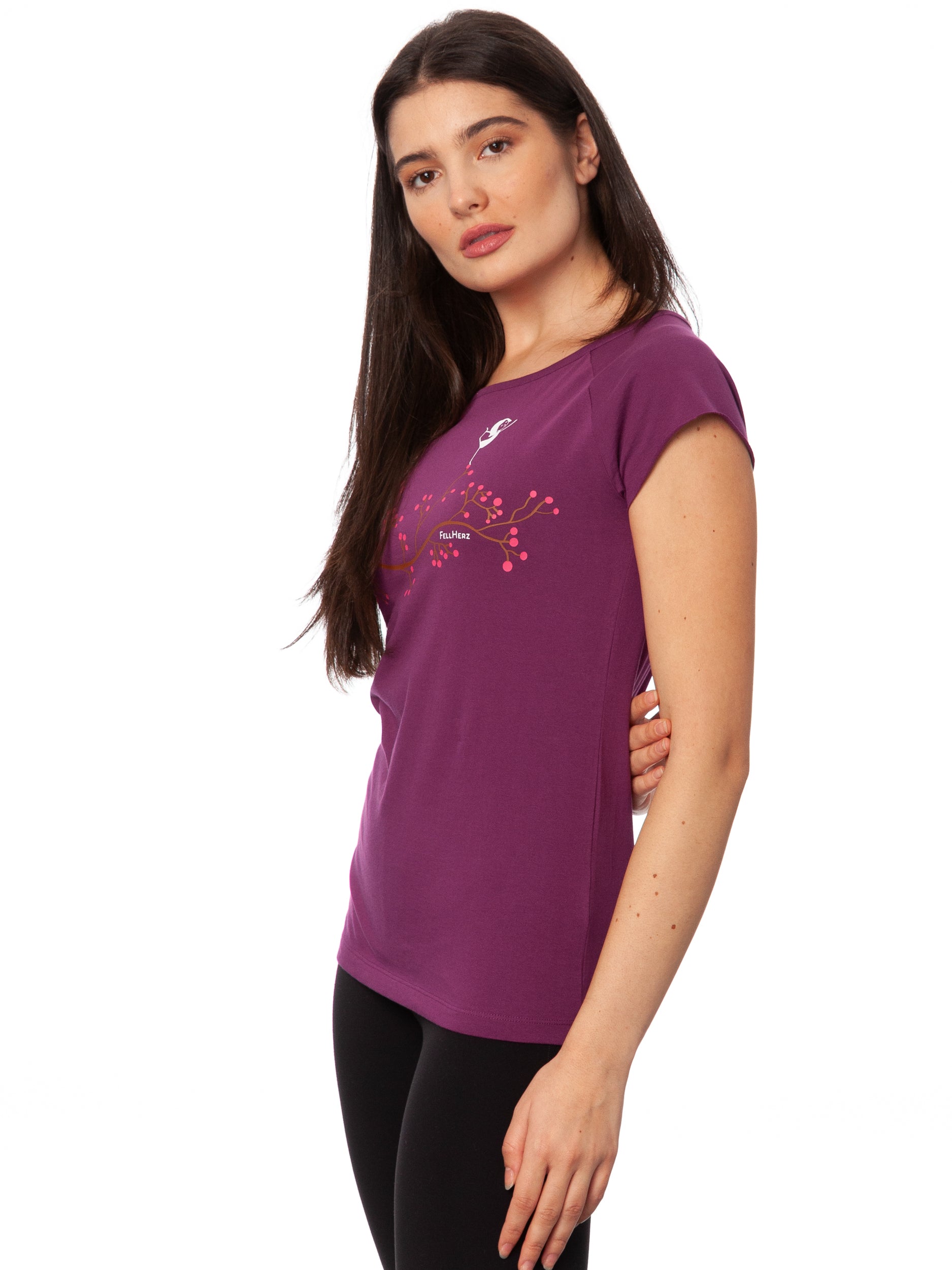 Lila Frauen Yoga T-Shirt mit Asana-Girl-Print auf der Brust: ein brauner Ast mit pinken Beeren, auf denen ein kleines Mädchen in Balance-Yogapose steht -nachhaltig produziert aus Bio-Baumwolle – modernes Cap Sleeve Shirt für Yoga, Freizeit und Meditation.