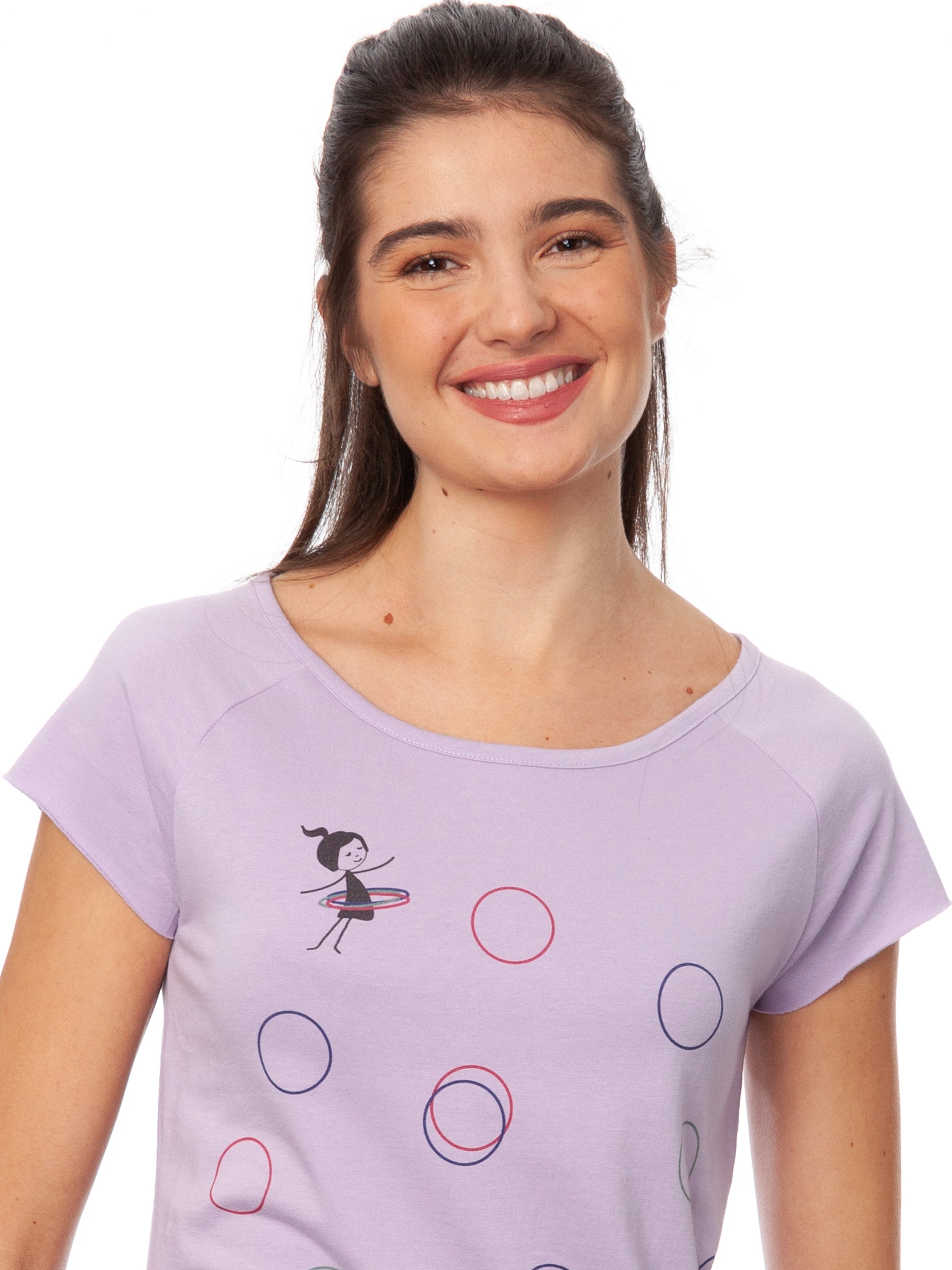 Flieder-farbenes Damen-T-Shirt mit Cap-Sleeve-Ärmeln, leicht tailliertem Schnitt und modernem Raglan-Design. Gefertigt aus 100 % hochwertiger Biobaumwolle unter fairen Bedingungen. Das Shirt verfügt über einen weiten Rundhalsausschnitt und einem Print auf der Vorderseite: ein kleines Mädchen mit bunten Hoolahoop Reifen als Brustprint und grafische Hoolahoopreifen in verschiedenen Farben über das Shirt verteilt. Nachhaltig produziert aus recycelten Stoffen und limitiert erhältlich