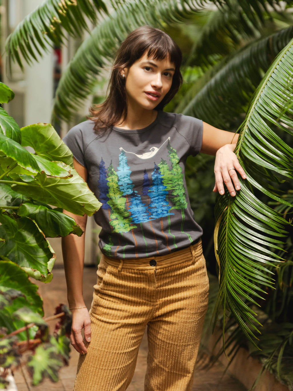 Dunkel-graues Damen T-Shirt aus Bio-Baumwolle, fair und vegan produziert. Raglan-Shirt mit Grafik-Print auf der Vorderseite: Ein Mädchen liegt in einer hängematte, die in Baum Wipfeln eines Waldes hängt.