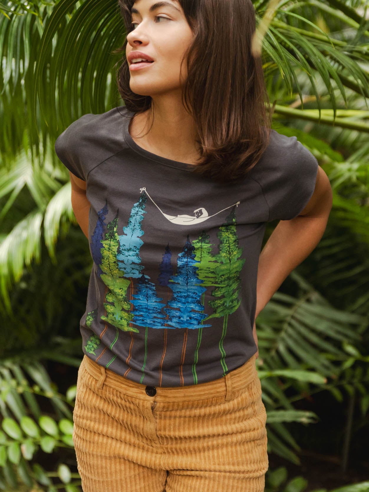 Dunkel-graues Damen T-Shirt aus Bio-Baumwolle, fair und vegan produziert. Raglan-Shirt mit Grafik-Print auf der Vorderseite: Ein Mädchen liegt in einer hängematte, die in den Wipfeln eines Waldes hängt.