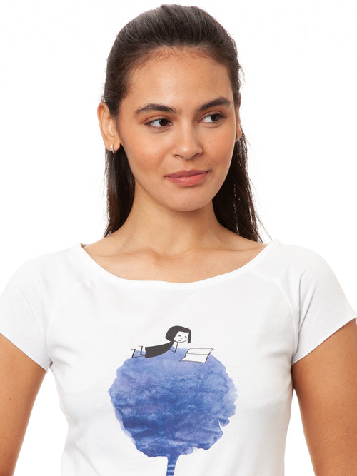 Model trägt das Damen Cap Sleeve T-Shirt Blumenbuch in Weiß – Mädchen mit Buch liegt auf einer blauen Blume, Bio-Baumwolle, fair und vegan produziert