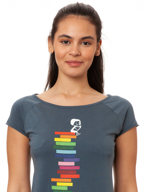 Model trägt das Damen Cap Sleeve T-Shirt Books Girl in Thundercloud-Blau – Motiv: Mädchen liest auf einem Stapel regenbogen-farbener Bücher, Bio-Baumwolle, fair und vegan produziert