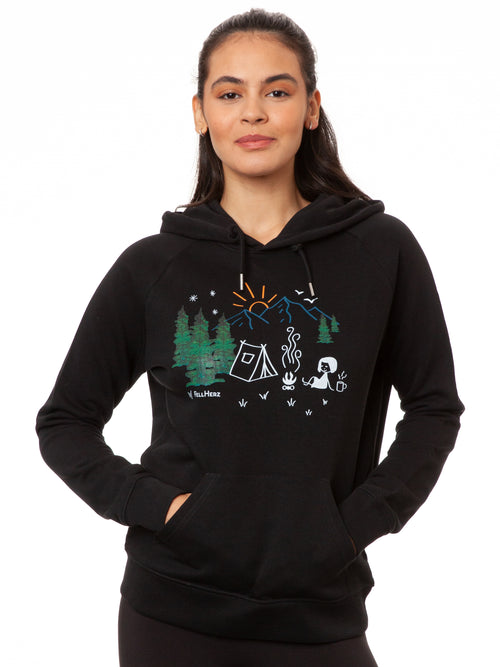 FellHerz Damen Hoodie Camping Girl in Schwarz aus 85% Bio-Baumwolle und 15% recyceltem Polyester, fair und vegan produziert – Raglan-Schnitt mit Kängurutasche und Digitaldruck: Mädchen vor einem Zelt beim Camping