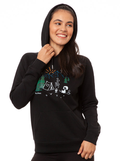 Model trägt den Damen Hoodie Camping Girl in Schwarz – Mädchen vor einem Zelt beim Camping, Bio-Baumwolle, fair und vegan produziert