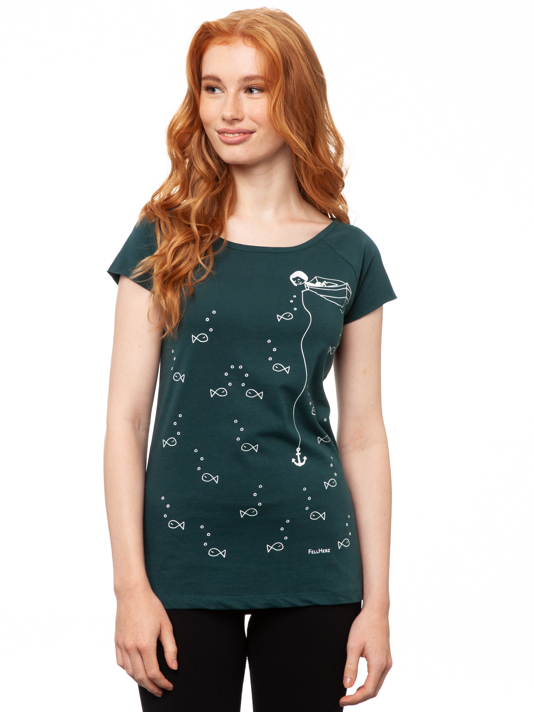 Ein Model trägt ein petrolfarbens Damen T‑Shirt aus 100 % Bio‑Baumwolle mit kurzen Cap‑Sleeves, maritimem Anker‑Siebdruck vorne und kleinem Logo‑Print auf dem Rücken – nachhaltig, fair produziert und lässig geschnitten