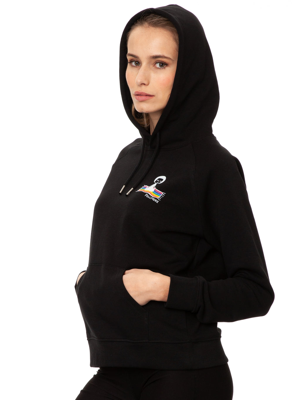Schwarzer Ommm‑Hoodie aus 85 % GOTS‑zertifizierter Bio‑Baumwolle und 15 % recyceltem Polyester im lässigen Raglan‑Schnitt, mit doppellagiger Kapuze und Ton‑in‑Ton‑Kordel, kuscheliger Kängurutasche und zarter FellHerz‑Illustration eines kleinen Mädchens, das auf einem regenbogenfarbenen Teppich fliegt, im Digitaldruck mit wasserbasierten Farben – nachhaltig, fair produziert und ideal für kalte Tage.