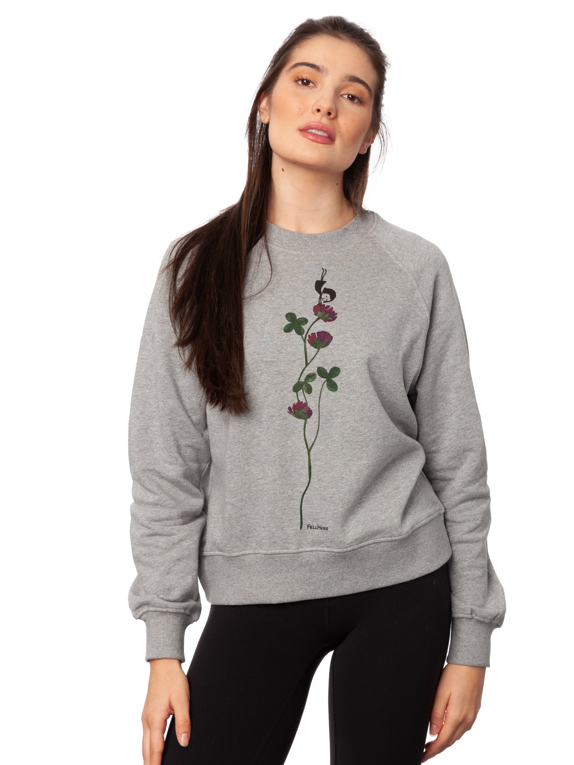 Damen Sweater hellgrau meliert mit Glücksklee-Design aus Biobaumwolle, Fair & Vegan hergestellt. Stilvoller Frauen Pullover mit nachhaltigem Druck ohne Schadstoffe – Fair Fashion von FellHerz. Der Grafik Print auf der Vorderseite zeigt ein kleines Mädchen, das Handstand macht auf einer blühenden Klee-Pflanze.