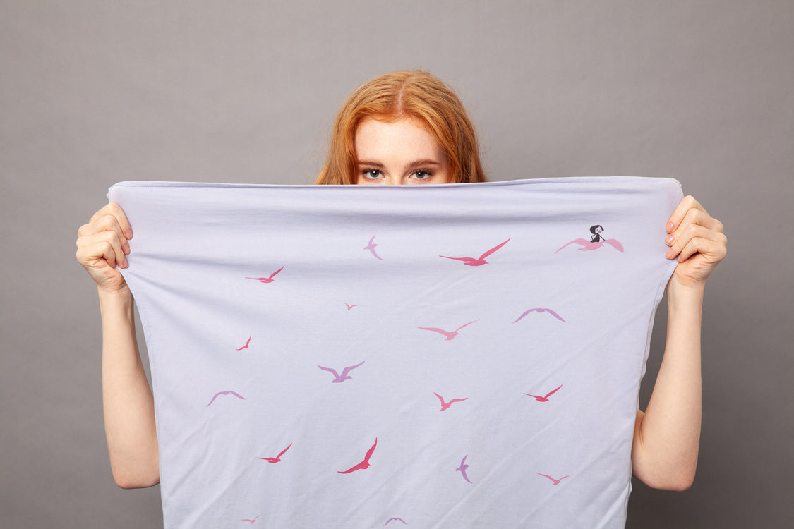 Frau die sich ein Furoshiki vor das Gesicht hält