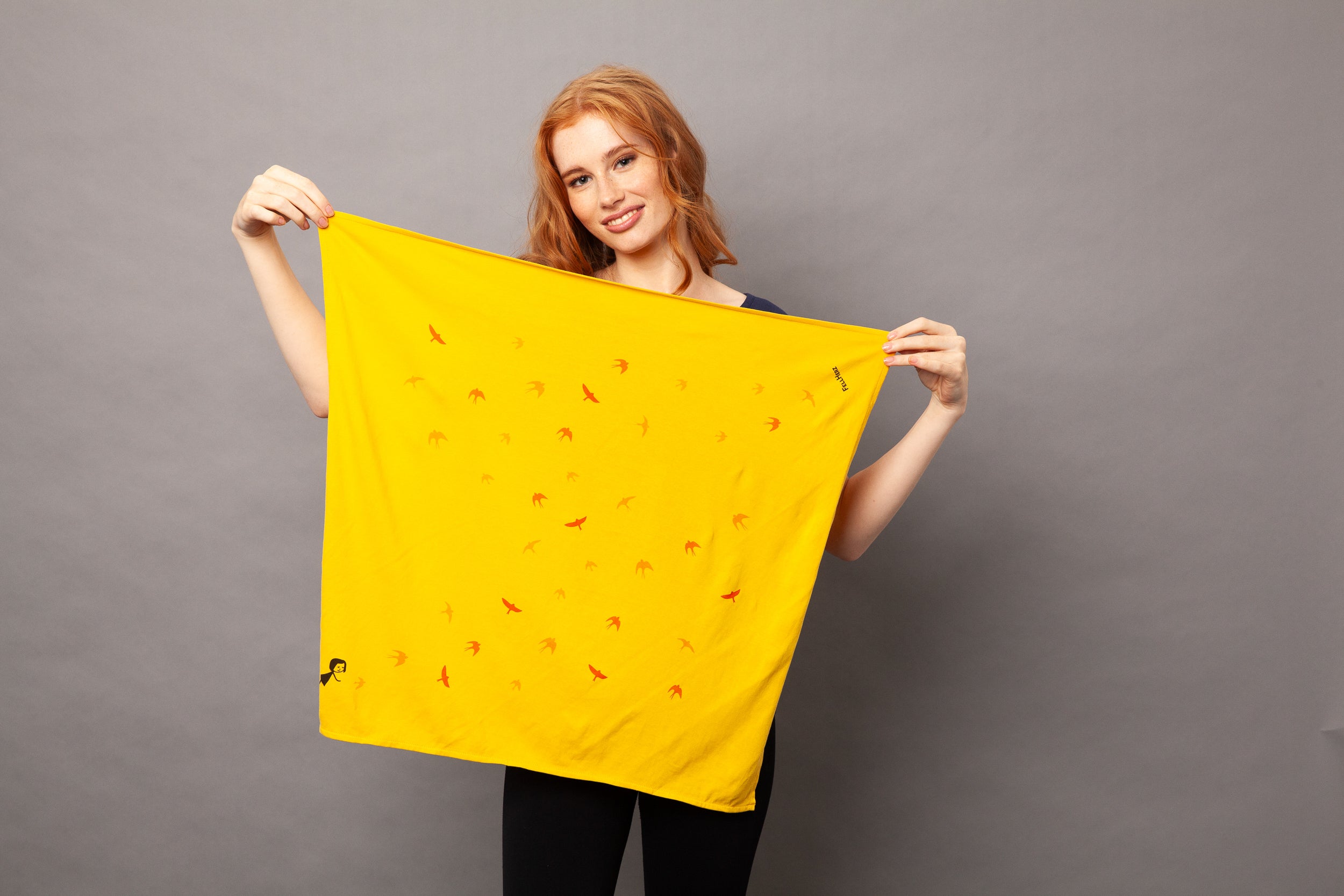 gelbes nachhaltiges FellHerz Furoshiki aus Bio-Baumwolle, fair und vegan produziert mit Schwalbenzug Grafik-Print: Ein kleines Mädchen steht im unteren Eck und es fliegen Vögel davon.