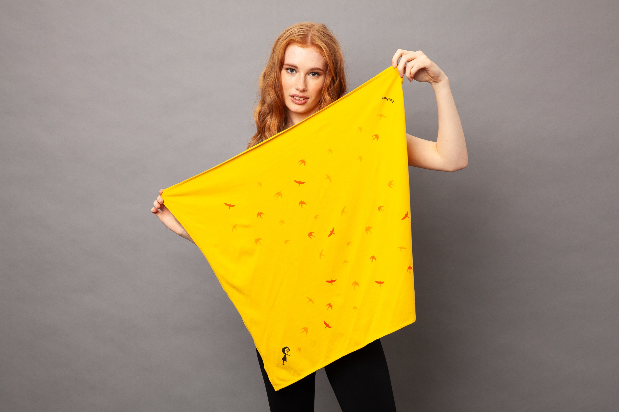 gelbes nachhaltiges FellHerz Furoshiki aus Bio-Baumwolle, fair und vegan produziert mit Schwalbenzug Grafik-Print: Ein kleines Mädchen steht im unteren Eck und es fliegen Vögel davon.