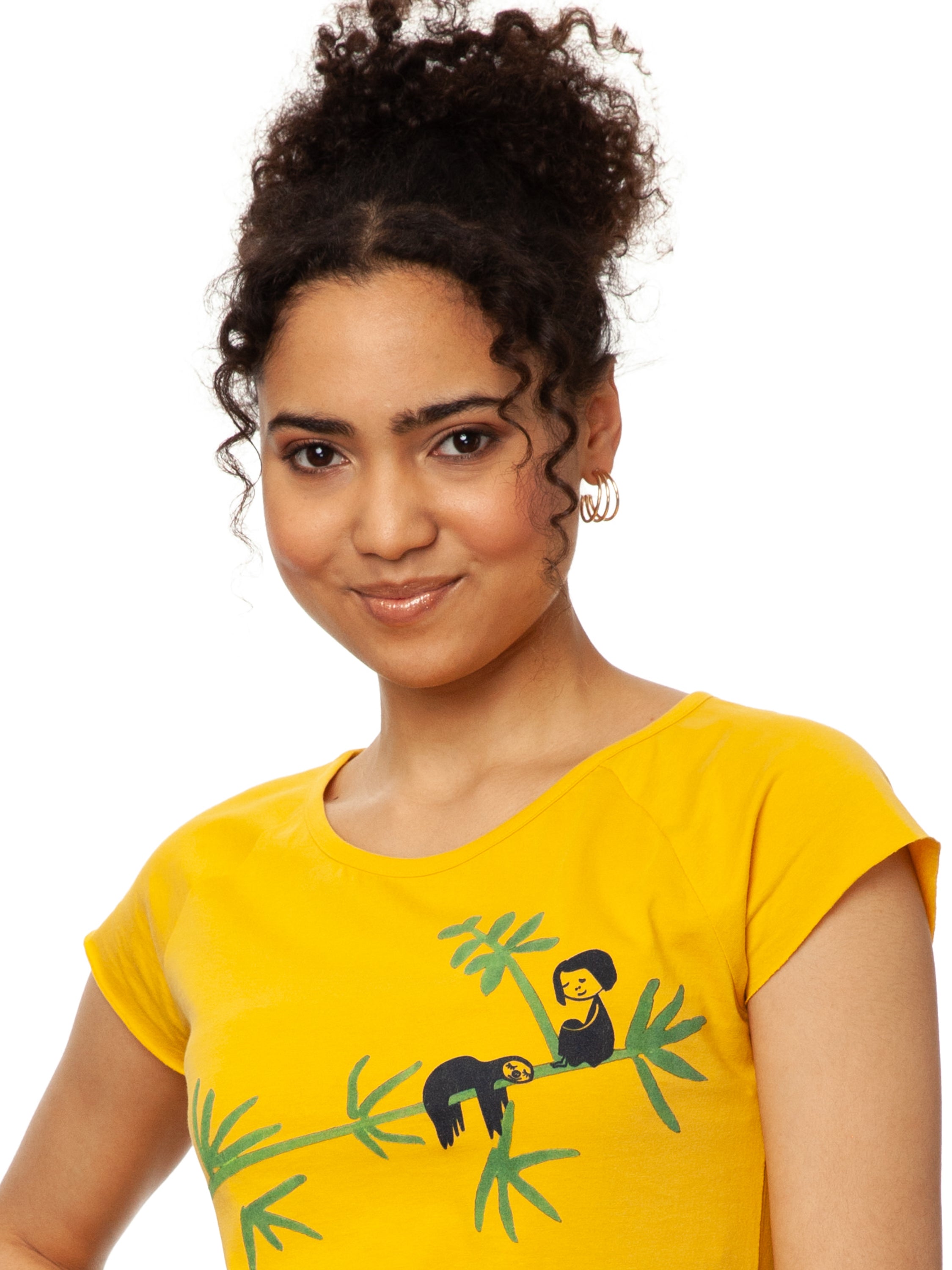 Das Damen T-Shirt aus hochwertiger Bio-Baumwolle in leuchtendem Sonnengelb mit einzigartigen FellHerz Faultier-Design in Grün auf der Vorderseite. Die liebevolle Illustration zeigt ein entspanntes Faultier, das sich an einem Zweig festhält, während ein kleines Mädchen daneben sitzt. Dieses nachhaltige Damen T-Shirt ist ideal für umweltbewusste Modefans und Fair Fashion Liebhaberinnen. Mit kurzen Cap-Sleeves und einem weiten Rundhalsausschnitt bietet das bequeme Baumwollshirt hohen Tragekomfort.