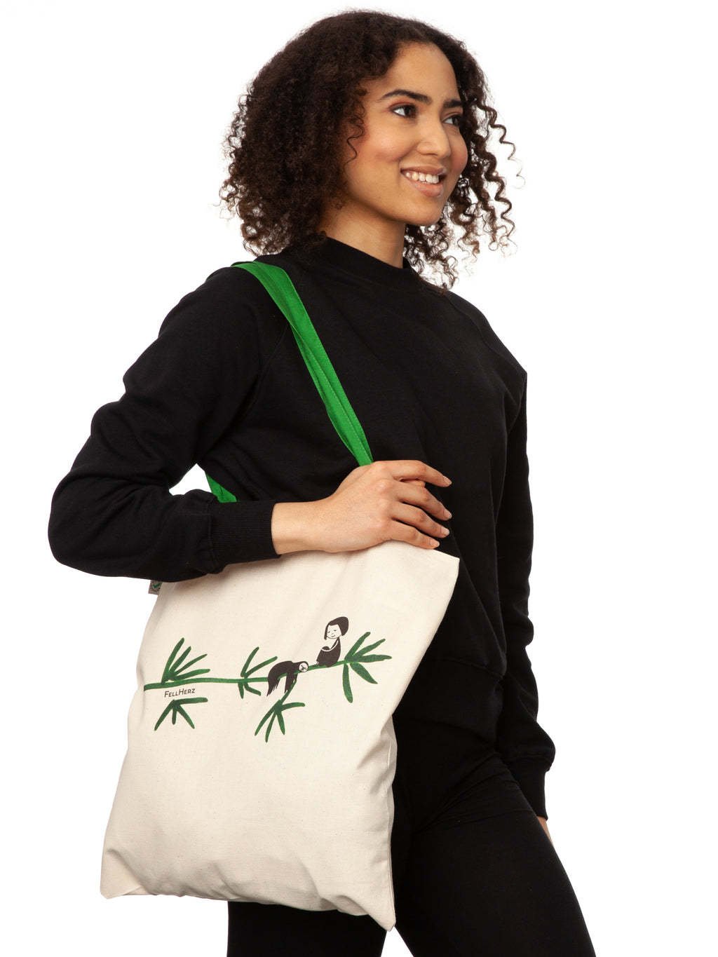 Tasche aus hochwertiger Bio-Baumwolle in Naturweiß mit grünen Henkeln mit einzigartigen FellHerz Faultier-Design in Grün auf der Vorderseite. Die liebevolle Illustration zeigt ein entspanntes Faultier, das sich an einem Zweig festhält, während ein kleines Mädchen daneben sitzt. Diese nachhaltige Bag ist ideal für umweltbewusste Modefans und Fair Fashion Liebhaberinnen und ist ein tolles Accessoire.