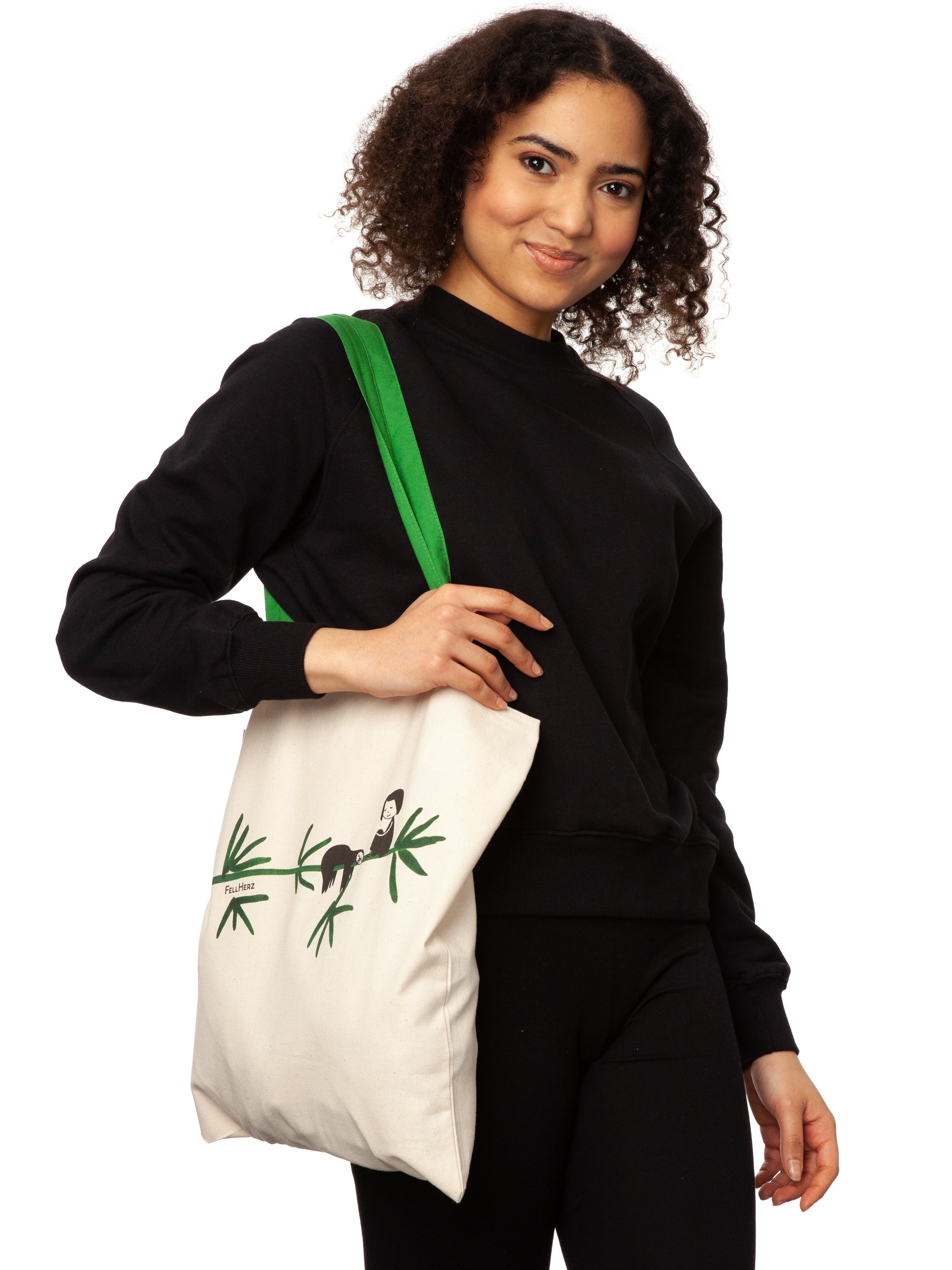 Tasche aus hochwertiger Bio-Baumwolle in Naturweiß mit grünen Henkeln mit einzigartigen FellHerz Faultier-Design in Grün auf der Vorderseite. Die liebevolle Illustration zeigt ein entspanntes Faultier, das sich an einem Zweig festhält, während ein kleines Mädchen daneben sitzt. Diese nachhaltige Bag ist ideal für umweltbewusste Modefans und Fair Fashion Liebhaberinnen und ist ein tolles Accessoire.
