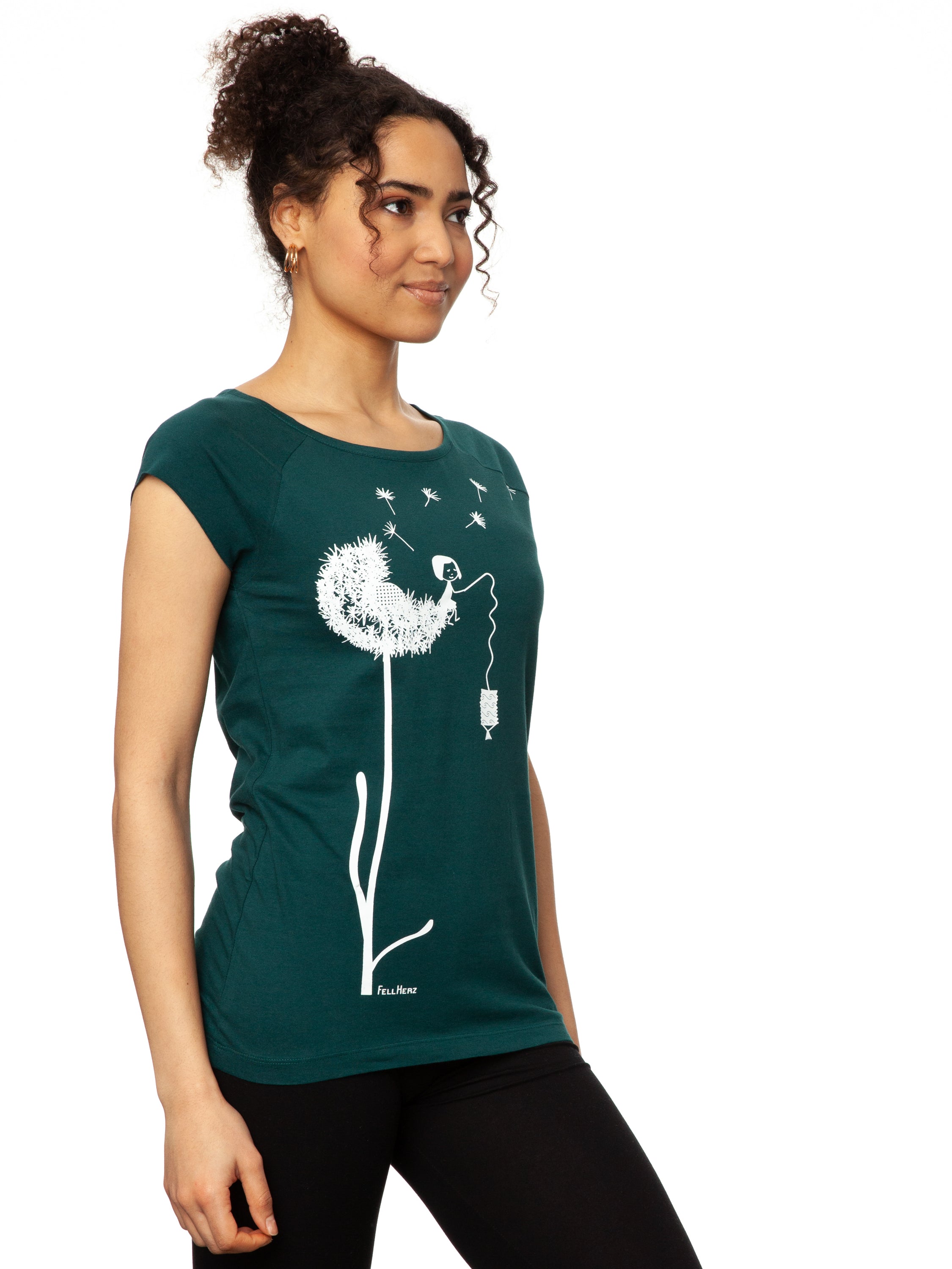 Das Damen T-Shirt in tiefem Petrolgrün besticht durch sein kreatives, weißes FellHerz-Pusteblumen-Print-Design auf der Vorderseite. Die Illustration zeigt ein Mädchen, das mit einer Laterne auf der Blume sitzt. Pusteblumen Samen fliegen davon. Das leicht taillierte Shirt hat kurze Cap-Sleeves, einen weiten Rundhalsausschnitt, besteht aus weicher, nachhaltiger Bio-Baumwolle und ist fair und vegan produziert. 