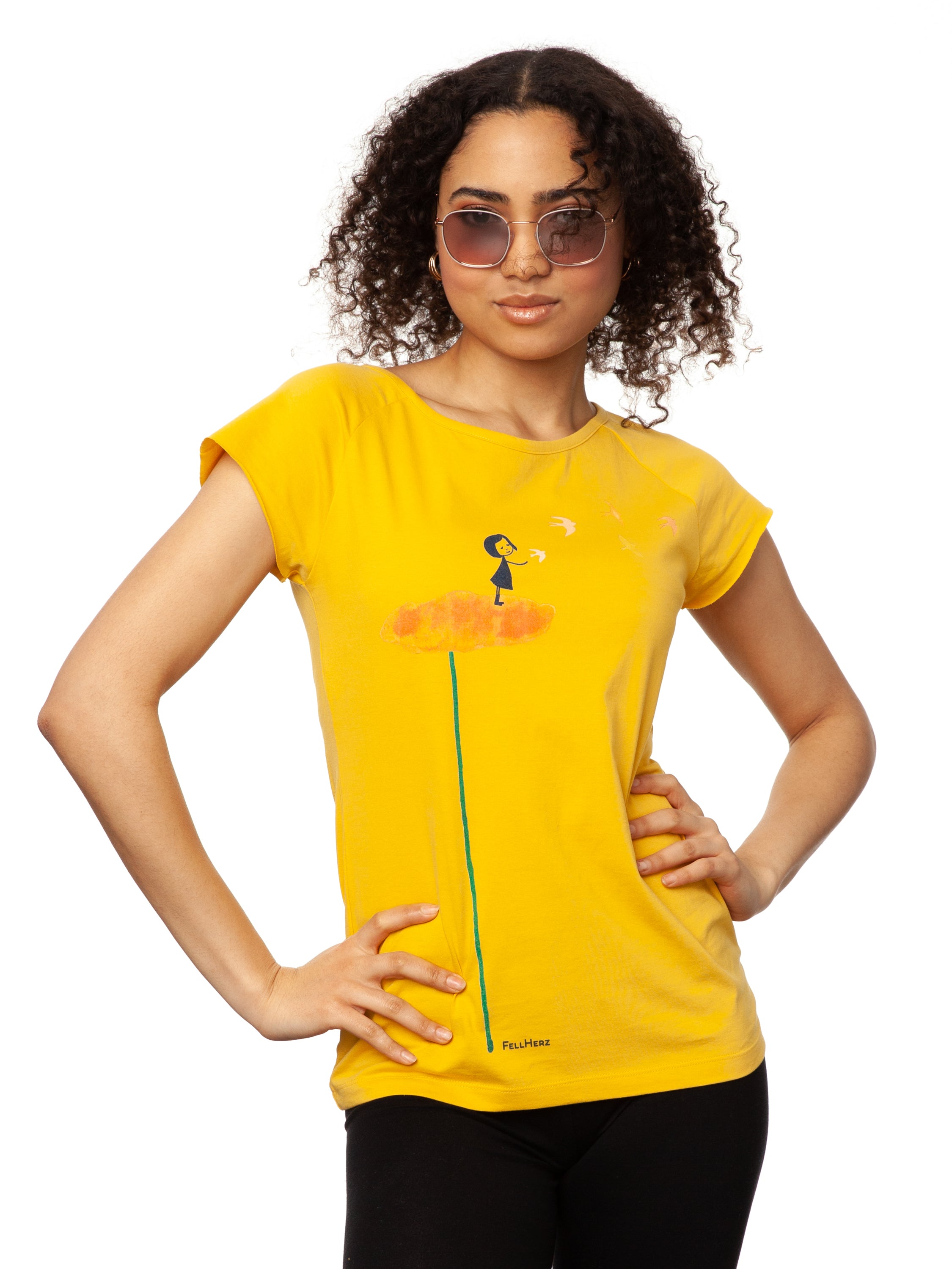 Gelbes nachhaltiges Damen T-Shirt aus Bio-Baumwolle, fair und vegan produziert. Raglan-Shirt mit Grafik-Print auf der Vorderseite: Ein Mädchen steht auf einer orangen Blume und es fliegen Vögel davon.