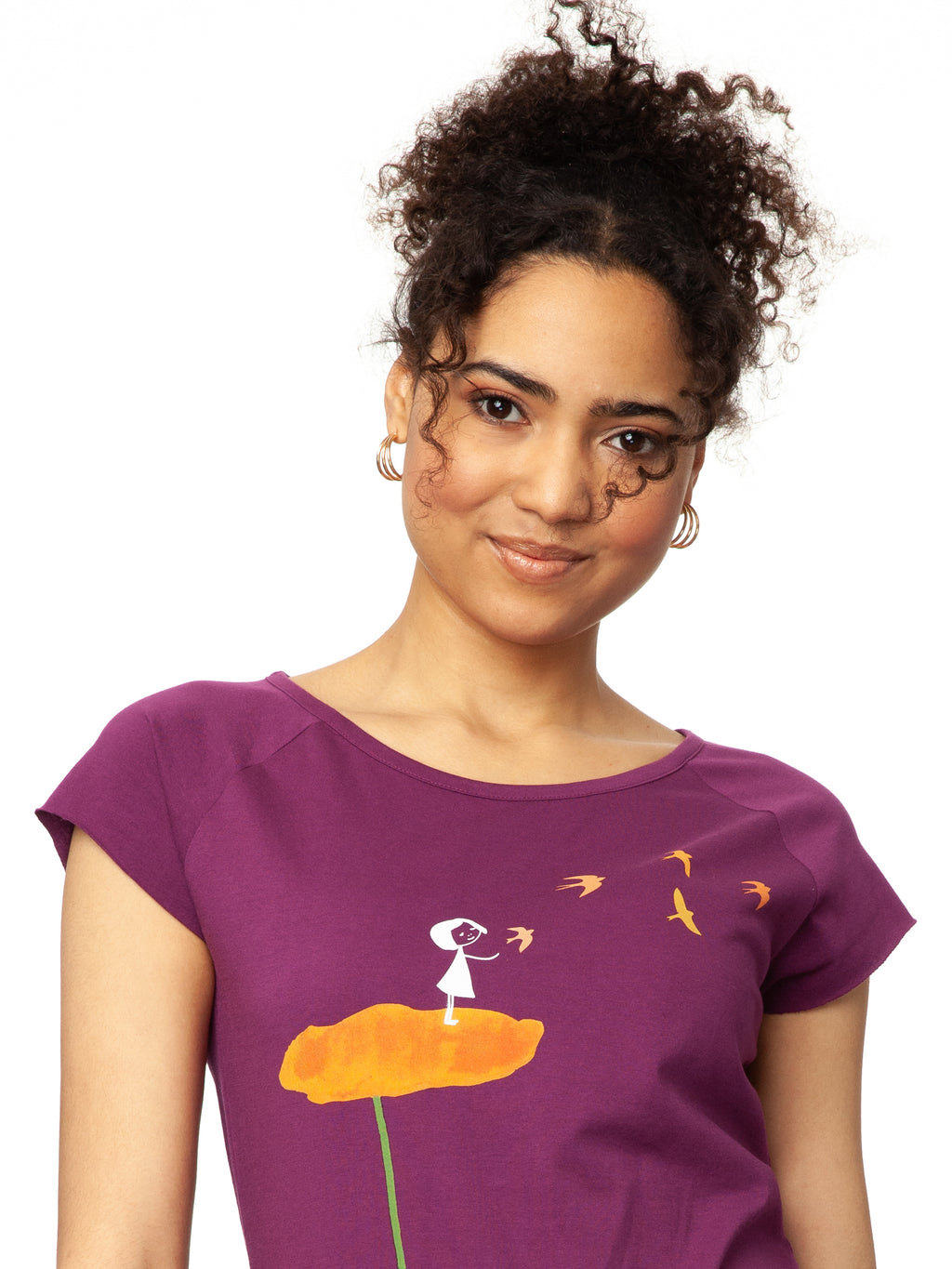 lila nachhaltiges Damen T-Shirt aus Bio-Baumwolle, fair und vegan produziert. Raglan-Shirt mit Grafik-Print auf der Vorderseite: Ein Mädchen steht auf einer orangen Blume und es fliegen Vögel davon.